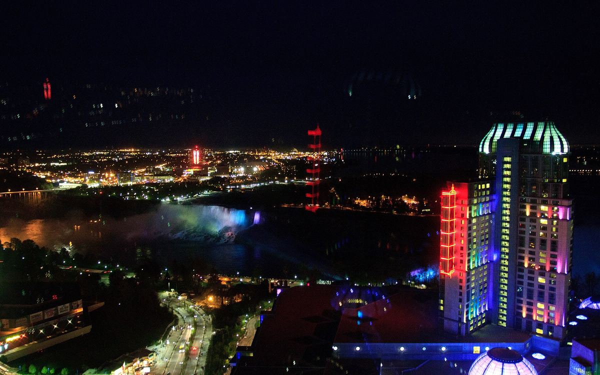 Fallsview Casino Resort lit up at night above the Niagara River and the American Falls, Ontario